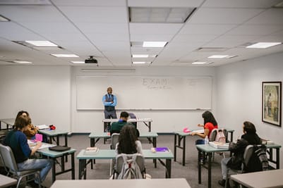 A professor delivering lecture to his class